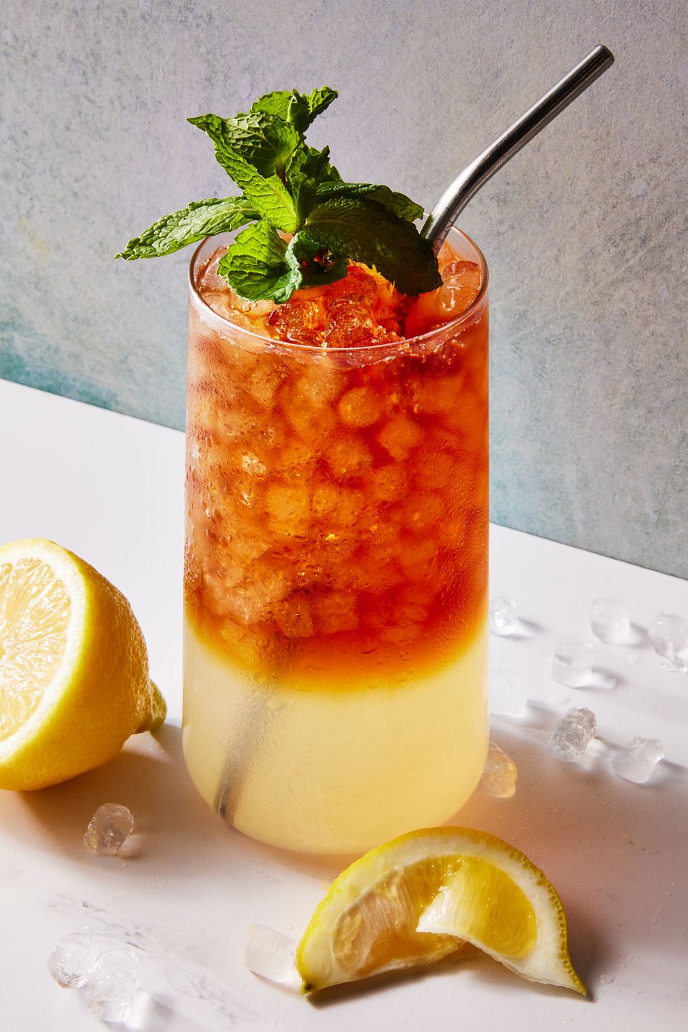 Arnold Palmer à pointes verre avec de la limonade en bas et du thé glacé en haut avec de la glace pilée, un jus de citron et de la menthe