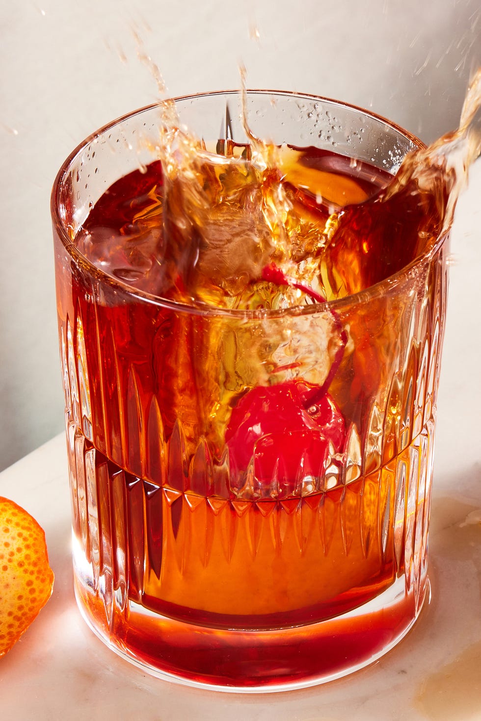 Cocktail à l'ancienne bourbon old fashioned avec sucre demerara, bitter, cerise au marasquin et zeste d'orange