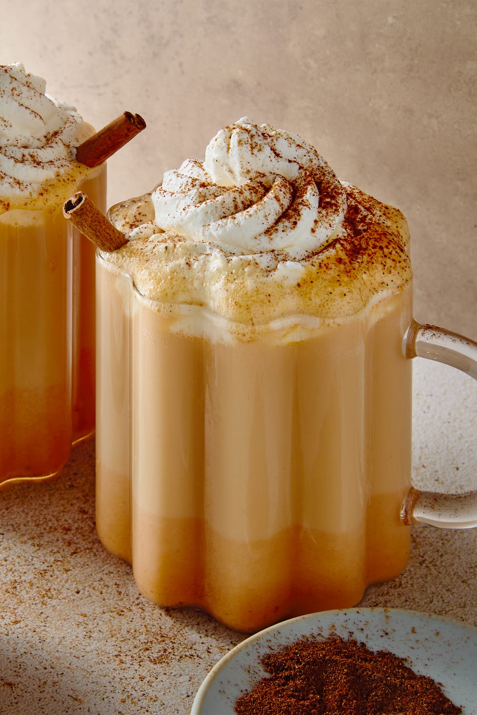 Chai Latte à la citrouille épicée Chai fraîchement infusé, agrémenté d'un shot de whisky et mélangé avec du lait, de la purée de citrouille et de la cannelle, puis garni de crème fouettée