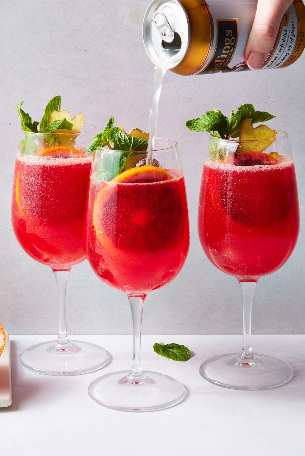 Spritzer pour cocktail sans alcool à l'orange sanguine cocktail sans alcool à l'orange sanguine avec une tranche d'orange sanguine, de la menthe et du gingembre
