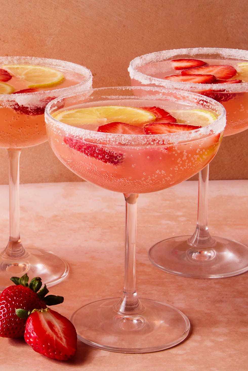 Jus de rire cocktail rose avec des tranches de fraises et du citron