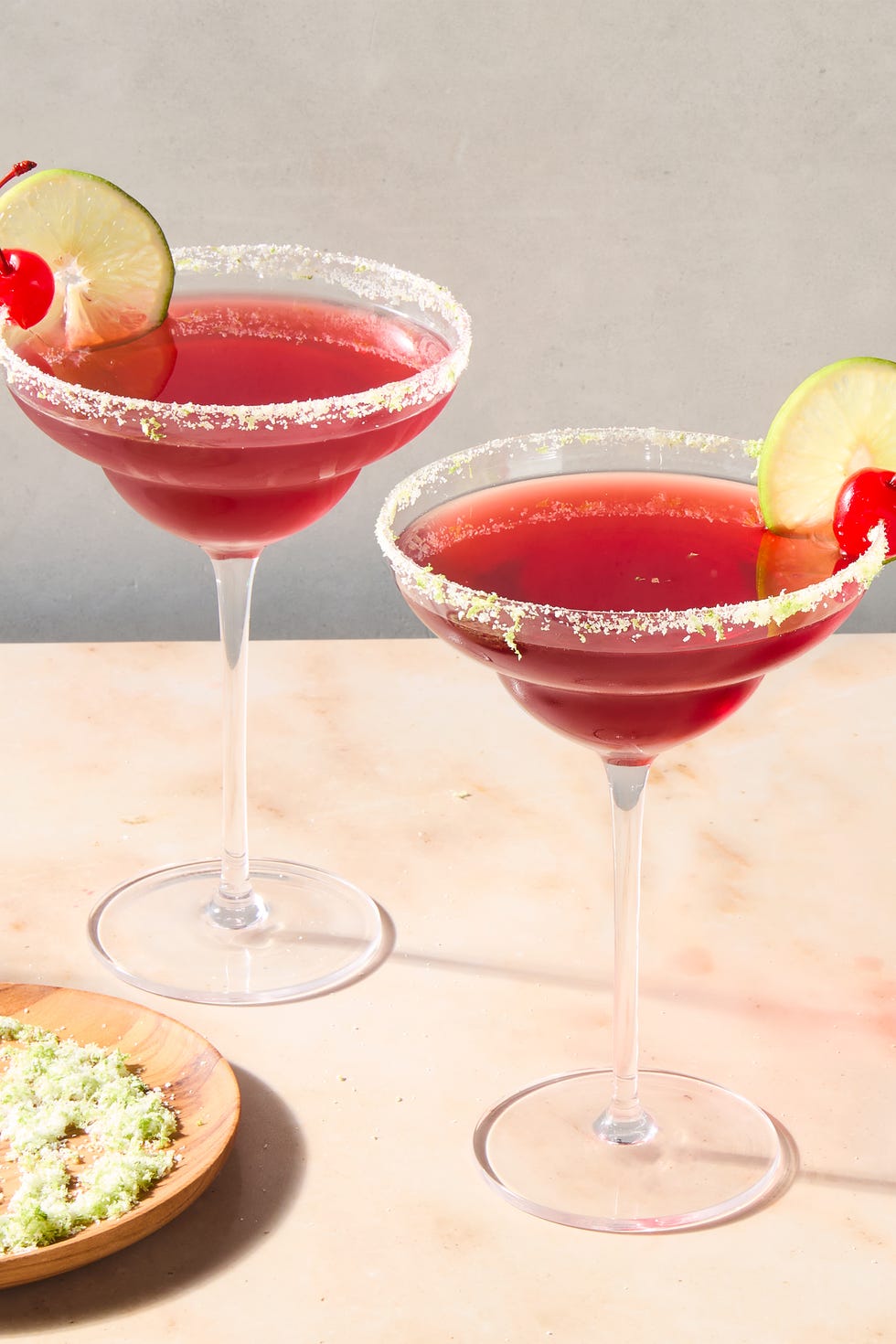 Margarita cerise-lime margarita cerise-lime avec bord de citron vert et garniture de cerise et citron vert