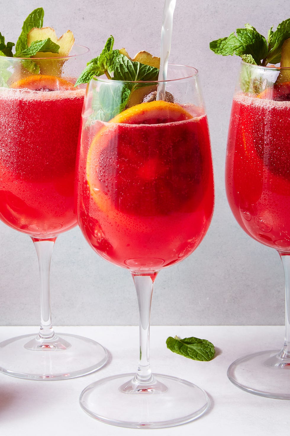 Spritzer pour cocktail sans alcool à l'orange sanguine cocktail sans alcool à l'orange sanguine avec une tranche d'orange sanguine, de la menthe et du gingembre
