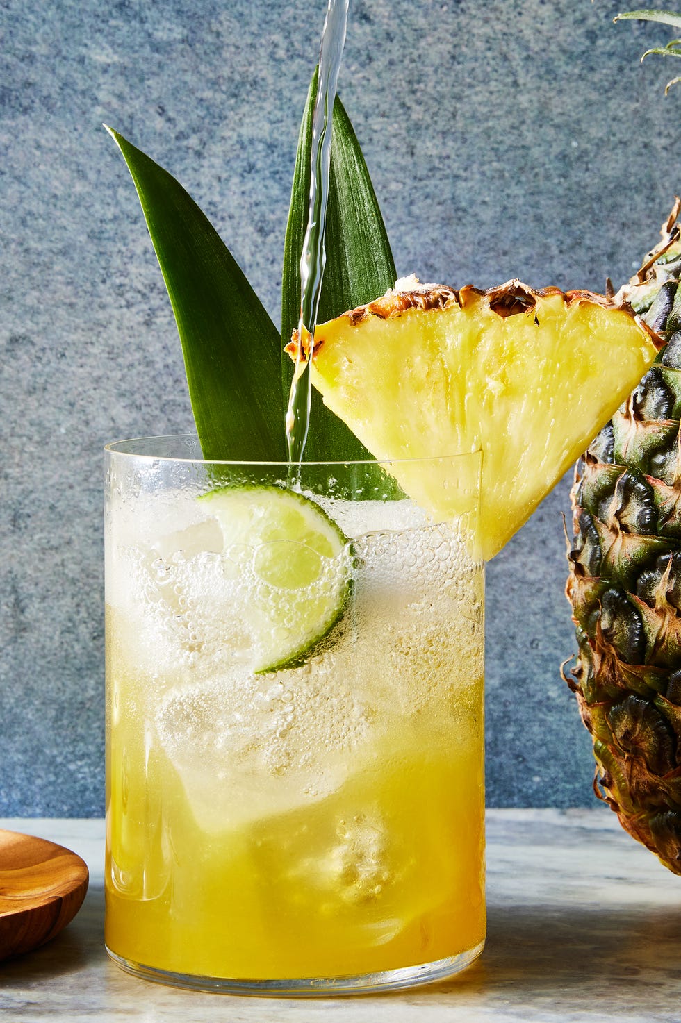 Spritz noix de coco et ananas spritz d'ananas à la noix de coco avec un quartier d'ananas et une garniture de feuilles d'ananas