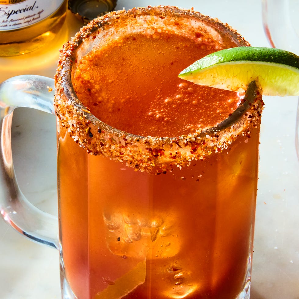 Michelada Michelada dans un verre avec une jante Tajin et une garniture au citron vert