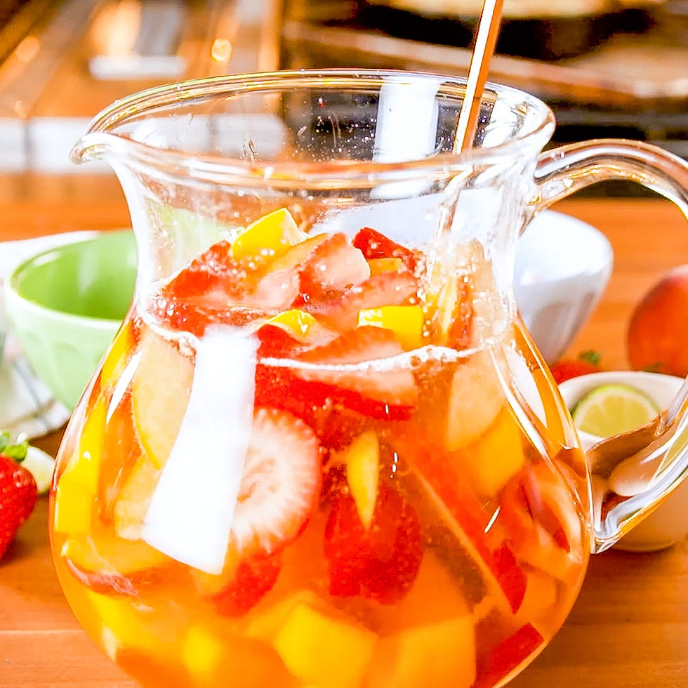 Boisson remplie de fruits dans un pichet avec des fruits supplémentaires en arrière-plan Boisson remplie de fruits dans un pichet avec des fruits supplémentaires en arrière-plan