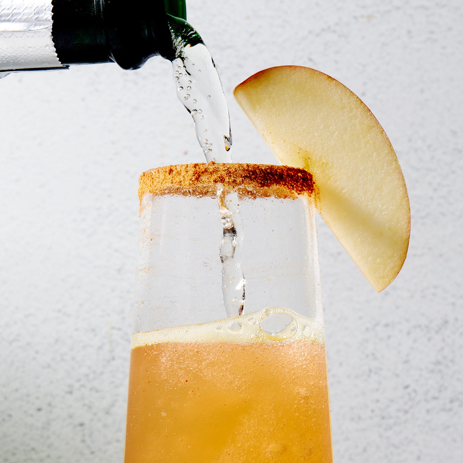 Mimosas au cidre de pomme Mimosas de cidre de pomme avec une bordure à la cannelle et des tranches de pomme