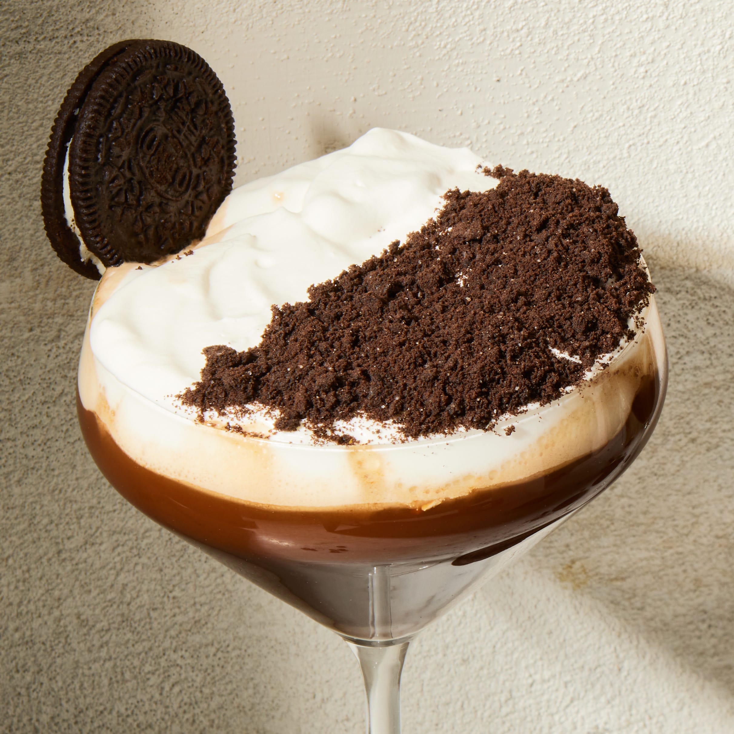 Mocktail expresso moka croquant Cocktail sans alcool expresso moka crunch dans un verre à martini avec une garniture à la crème fouettée et au chocolat et une garniture oreo