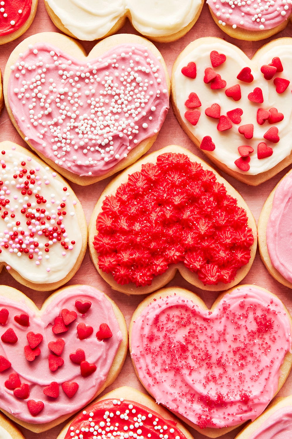 Biscuits Coeur biscuits au sucre en forme de coeur glacés avec un glaçage et des pépites rouges, blanches et roses